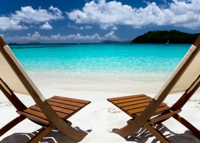 Empty beach chairs on beach overlooking ocean